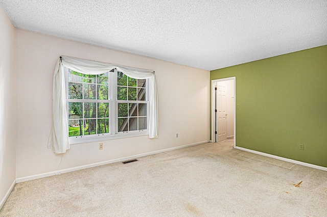 carpeted spare room with a textured ceiling