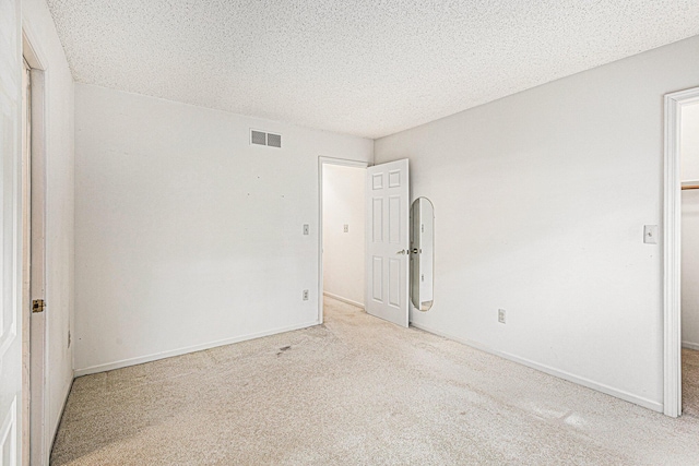 carpeted spare room featuring a textured ceiling