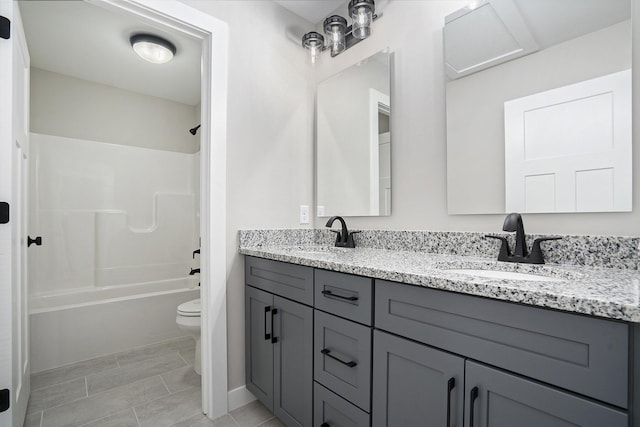 bathroom with double vanity, toilet, shower / tub combination, and a sink