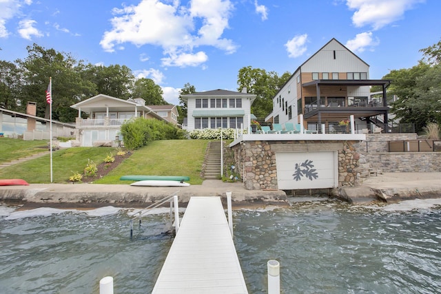 dock area featuring a deck with water view and a yard