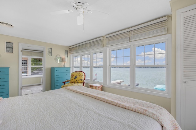 unfurnished bedroom with a closet, ceiling fan, and a water view