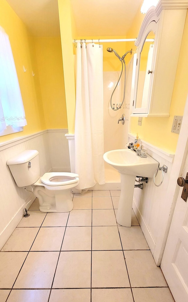 bathroom featuring walk in shower, tile patterned floors, and toilet