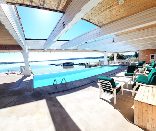 view of pool with a patio area and a water view