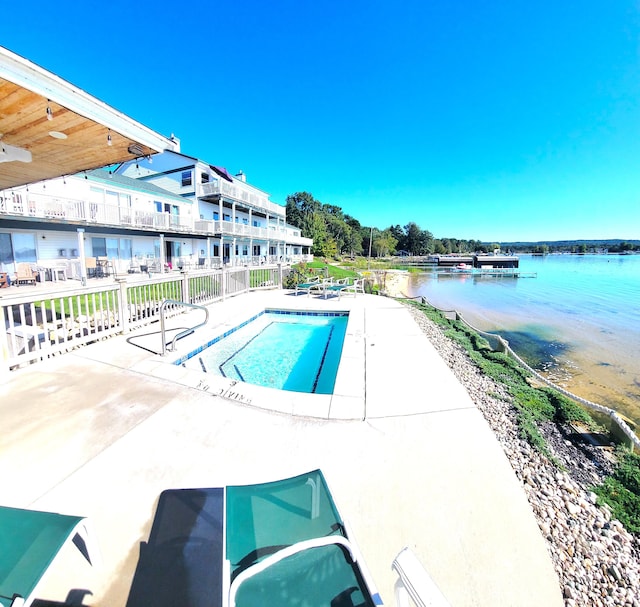 view of pool featuring a patio and a water view