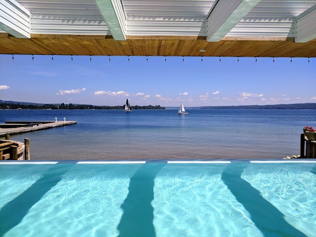 pool at dusk featuring a water view