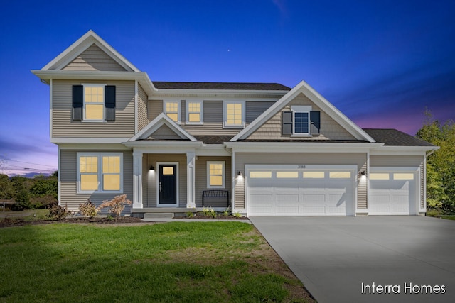 craftsman-style home featuring a garage and a lawn