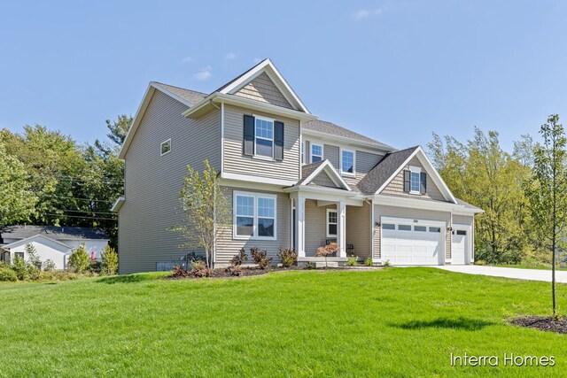 craftsman house featuring a garage and a front lawn