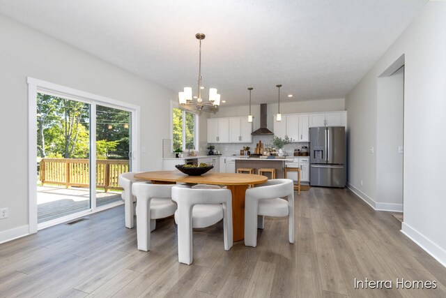 dining area featuring sink, a chandelier, and light wood-type flooring