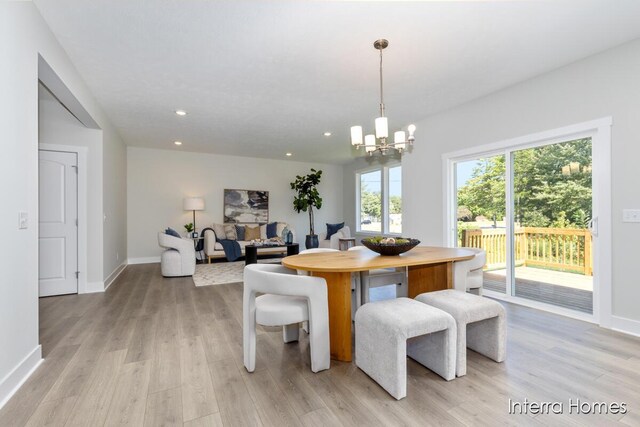 dining space featuring a notable chandelier and light wood-type flooring