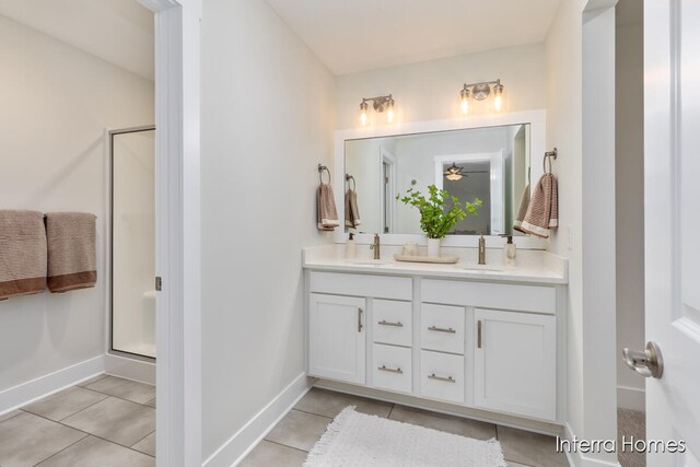 bathroom with tile patterned floors, ceiling fan, a shower with shower door, and vanity