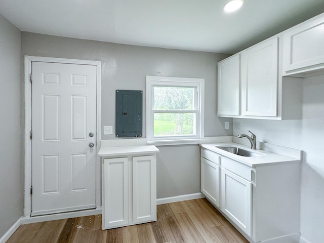 washroom featuring sink, electric panel, and light hardwood / wood-style floors