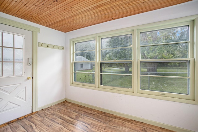 empty room featuring wood ceiling, wood-type flooring, and a wealth of natural light