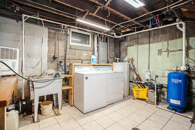 laundry area with electric panel, washing machine and clothes dryer, and light tile patterned flooring