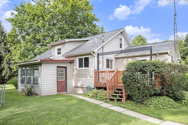 back of property with a wooden deck and a lawn