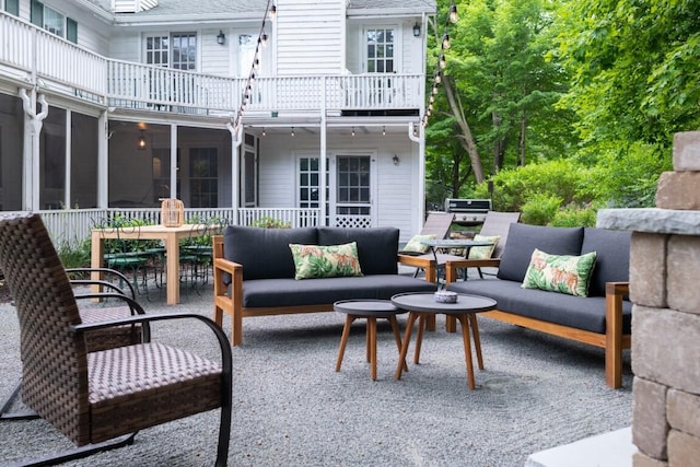 view of patio / terrace with a sunroom, a balcony, and an outdoor hangout area