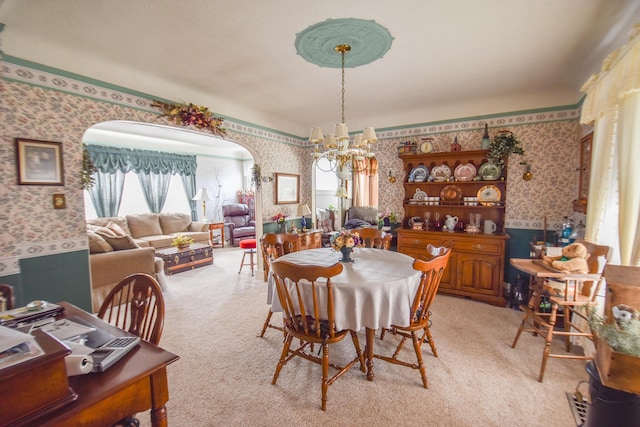 dining area with a notable chandelier and light colored carpet