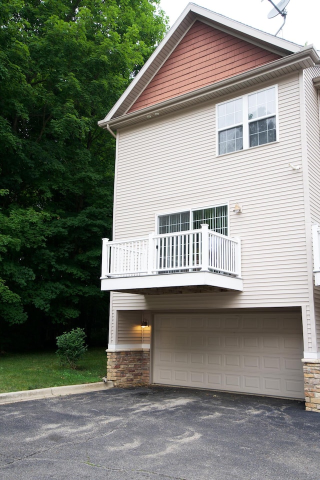 view of home's exterior with a balcony and a garage