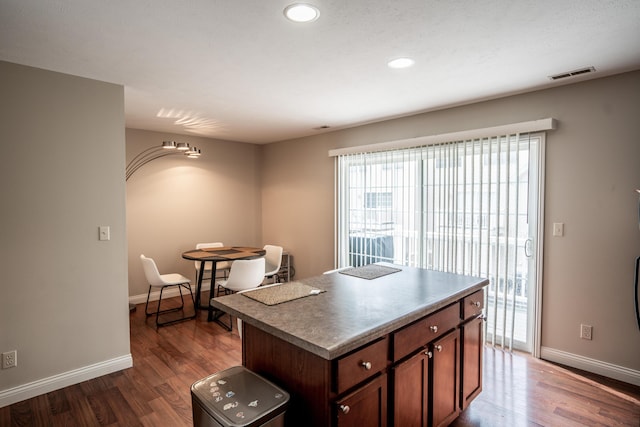 kitchen with dark hardwood / wood-style flooring and a center island