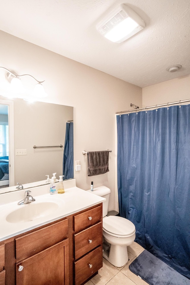 bathroom featuring tile patterned flooring, a shower with shower curtain, vanity, a textured ceiling, and toilet