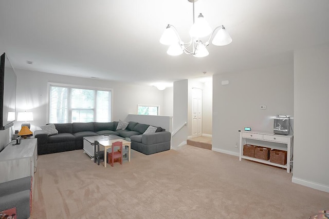 carpeted living room with an inviting chandelier