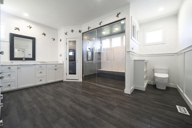 bathroom with wood-type flooring, vanity, toilet, and crown molding