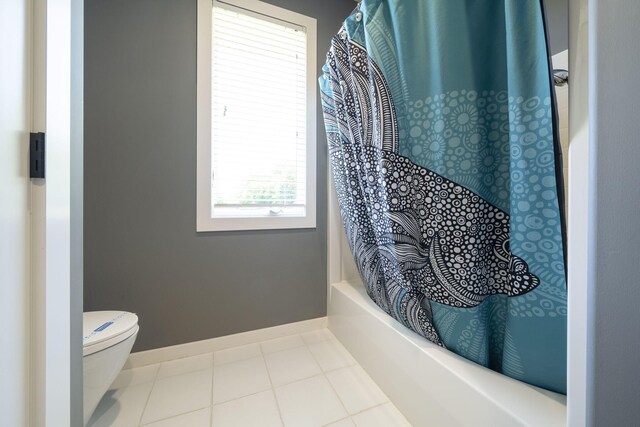 bathroom featuring tile patterned flooring, shower / bath combination with curtain, and toilet