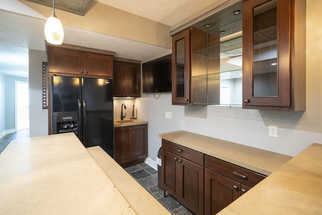 kitchen with black refrigerator with ice dispenser, sink, and pendant lighting