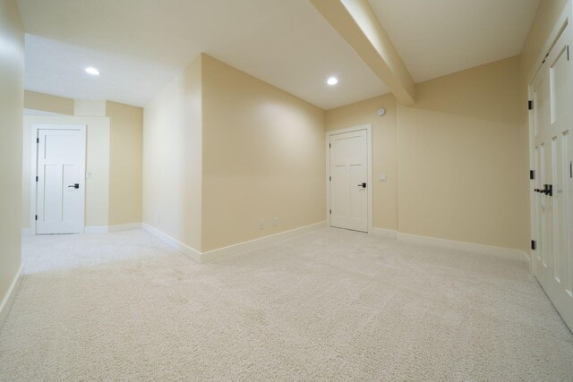 carpeted spare room with beamed ceiling