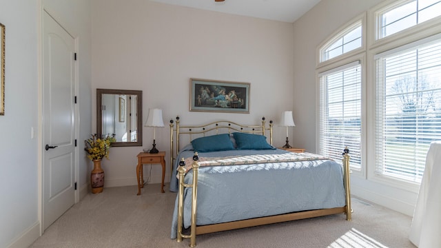 bedroom featuring multiple windows and light carpet