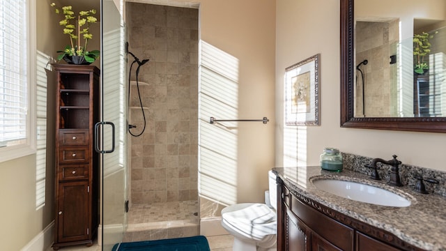 bathroom with tile patterned flooring, vanity, an enclosed shower, and toilet