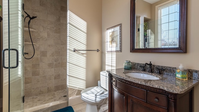 bathroom featuring a shower with door, vanity, tile patterned floors, and toilet