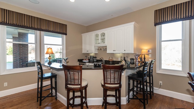 bar featuring white cabinetry and dark hardwood / wood-style flooring