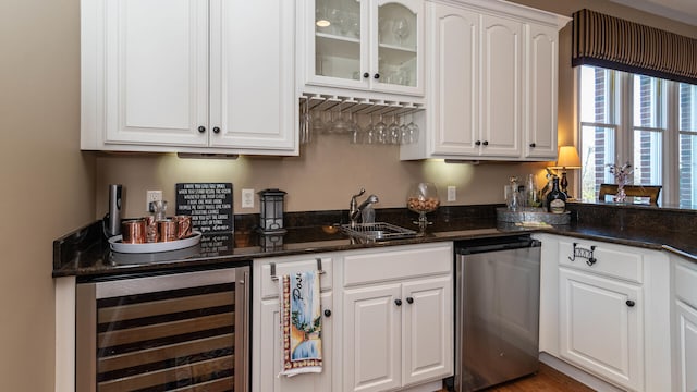 bar with dishwasher, white cabinetry, sink, dark stone countertops, and beverage cooler