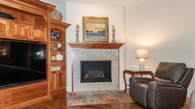 living room with a high end fireplace and dark hardwood / wood-style flooring