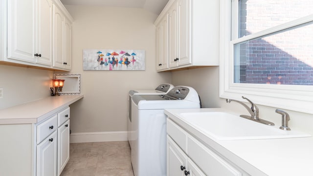 clothes washing area with cabinets, washing machine and dryer, sink, and light tile patterned floors