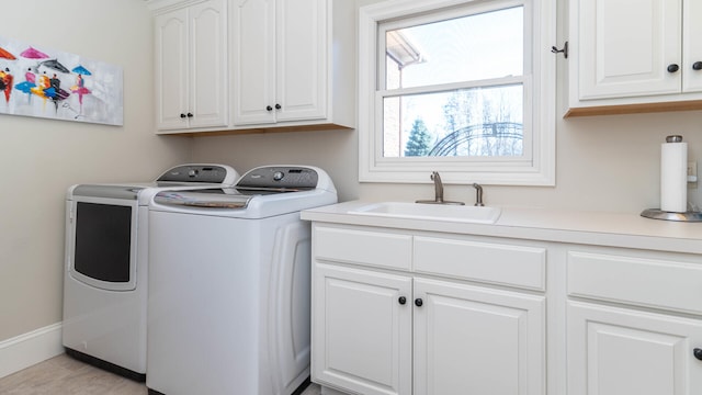 laundry room featuring cabinets, washing machine and dryer, and sink