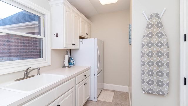 kitchen featuring white cabinetry, white refrigerator, vaulted ceiling, and sink