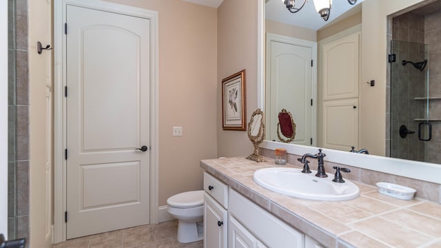 bathroom featuring tile patterned flooring, vanity, toilet, and walk in shower