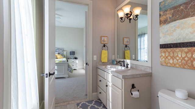 bathroom featuring vanity, an inviting chandelier, and toilet