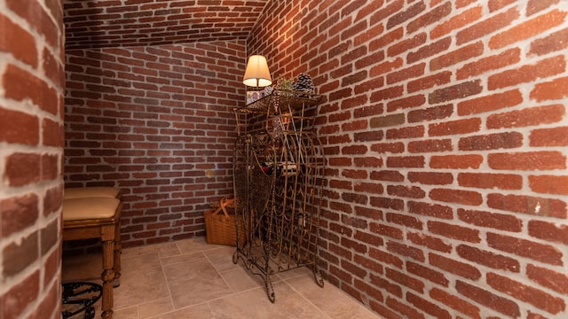 wine cellar featuring brick wall and vaulted ceiling