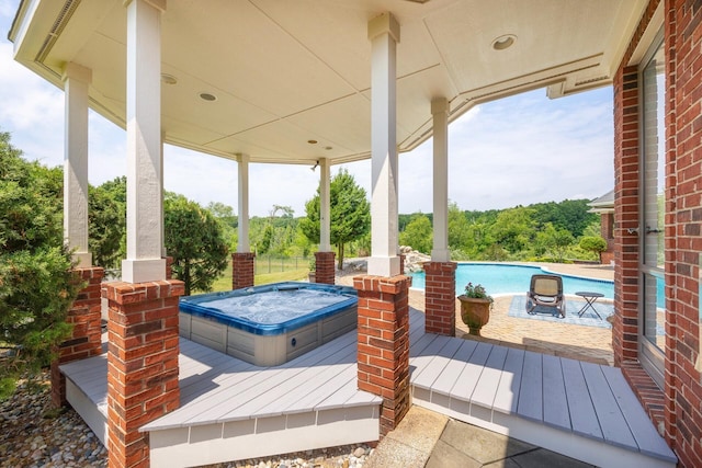 wooden deck with a pool with hot tub