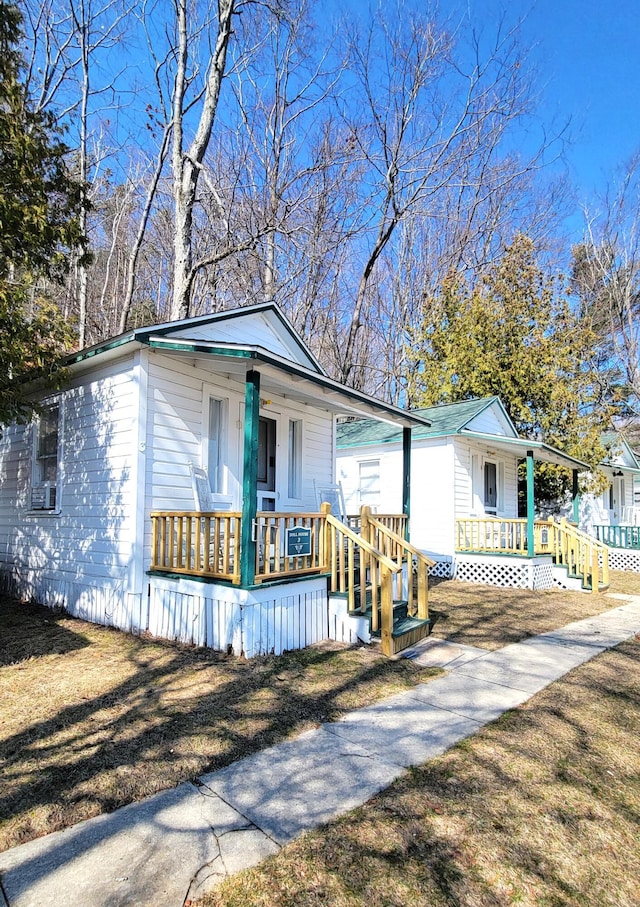 view of front of home with a porch and a front lawn