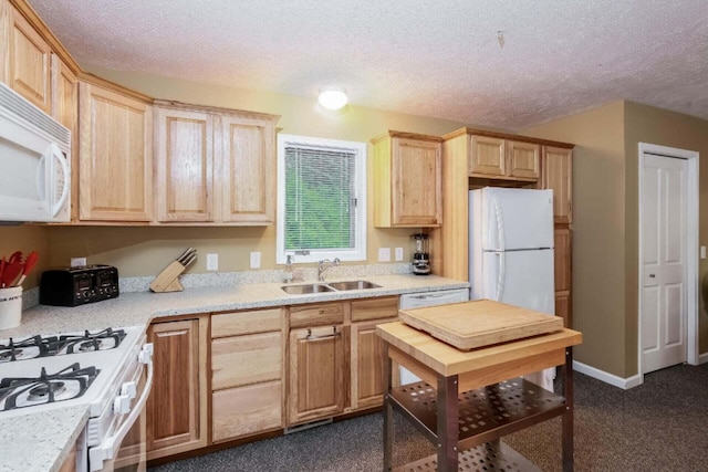 kitchen featuring a textured ceiling, white appliances, light brown cabinets, and sink