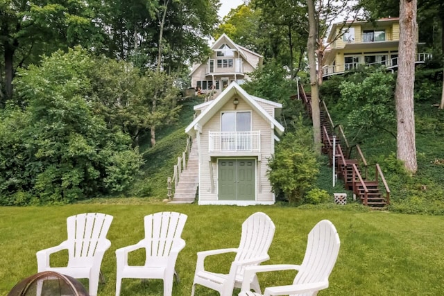 back of property featuring a balcony and a yard