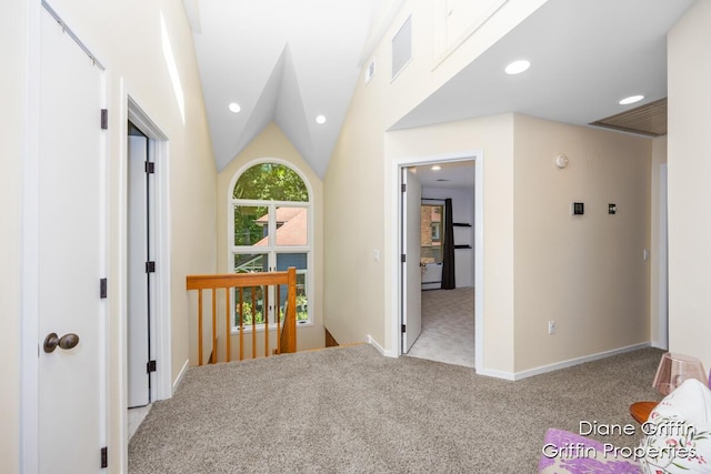 corridor featuring light carpet and vaulted ceiling