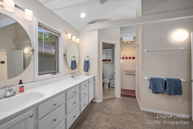 bathroom with a tile shower, vanity, lofted ceiling, and toilet