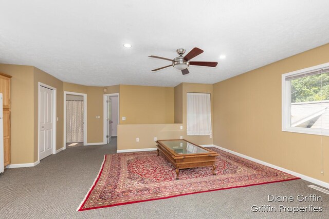 unfurnished living room featuring ceiling fan and carpet floors