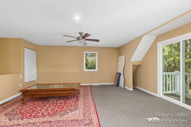 living area with ceiling fan and carpet