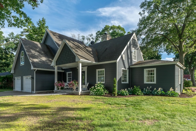 view of front facade featuring a garage, covered porch, and a front yard