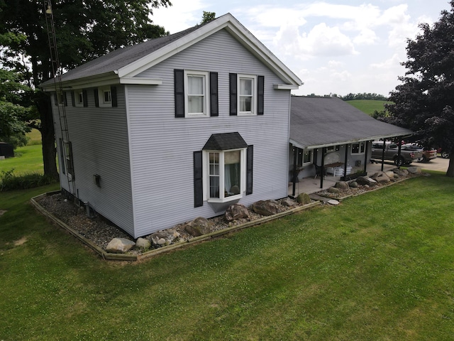 view of side of home with a patio area and a lawn